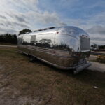 Close-up of polished Airstream showing detailed, sharp reflections.