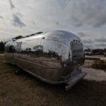 Close-up of polished Airstream showing detailed, sharp reflections.